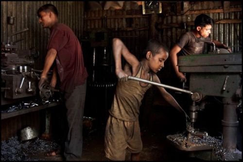 A young laborer making metal components at a factory. Dhaka.Bangladesh 